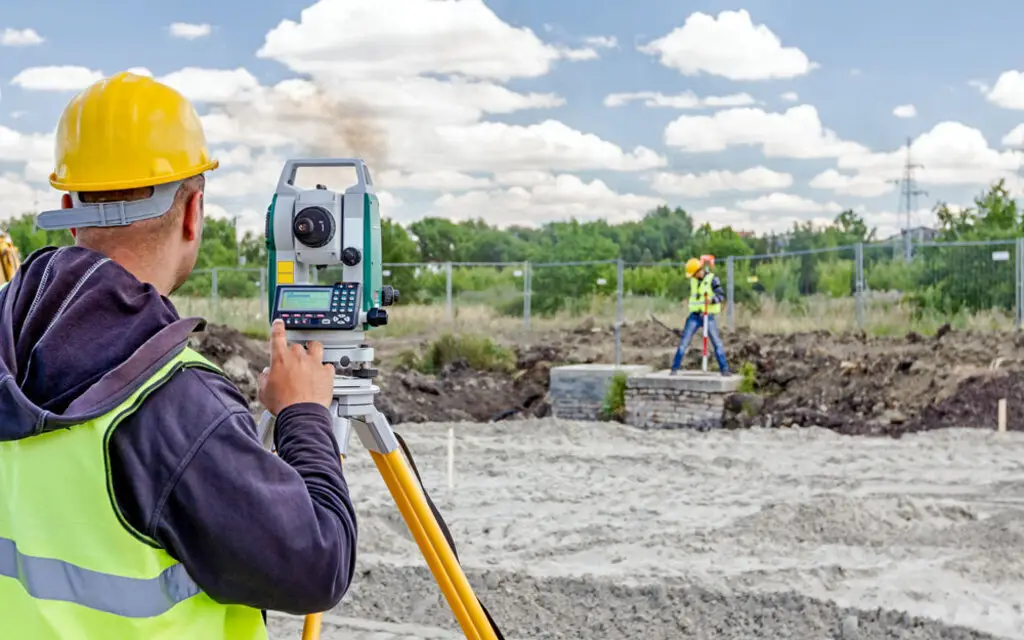 geodesist is working with total station on a building site. civi